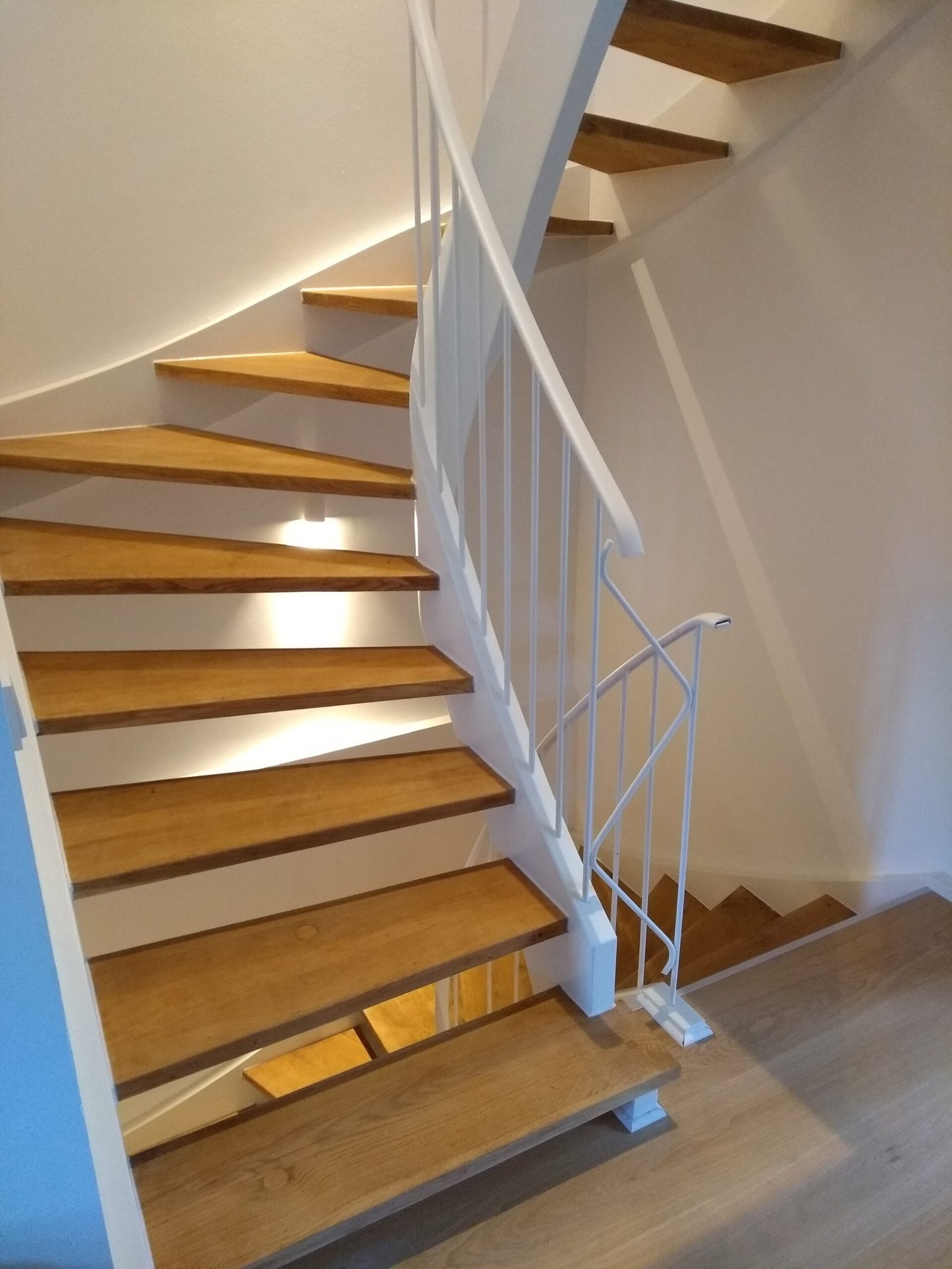Gewendelte Treppe mit weiß lackierter Wange und frisch geölten Eichenstufen